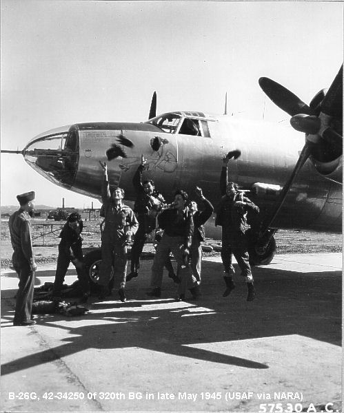 Members of the 320th Bomb Group tossing caps near a B-26G at the end of World War II
