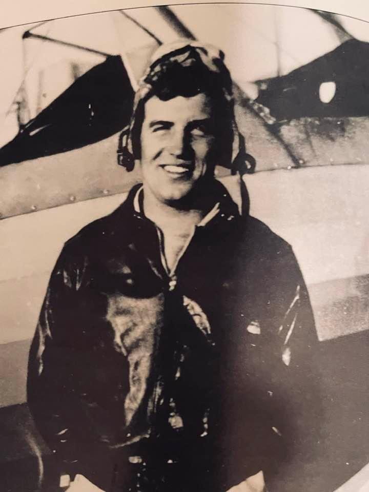 Robert A. Cary in flight gear beside an aircraft